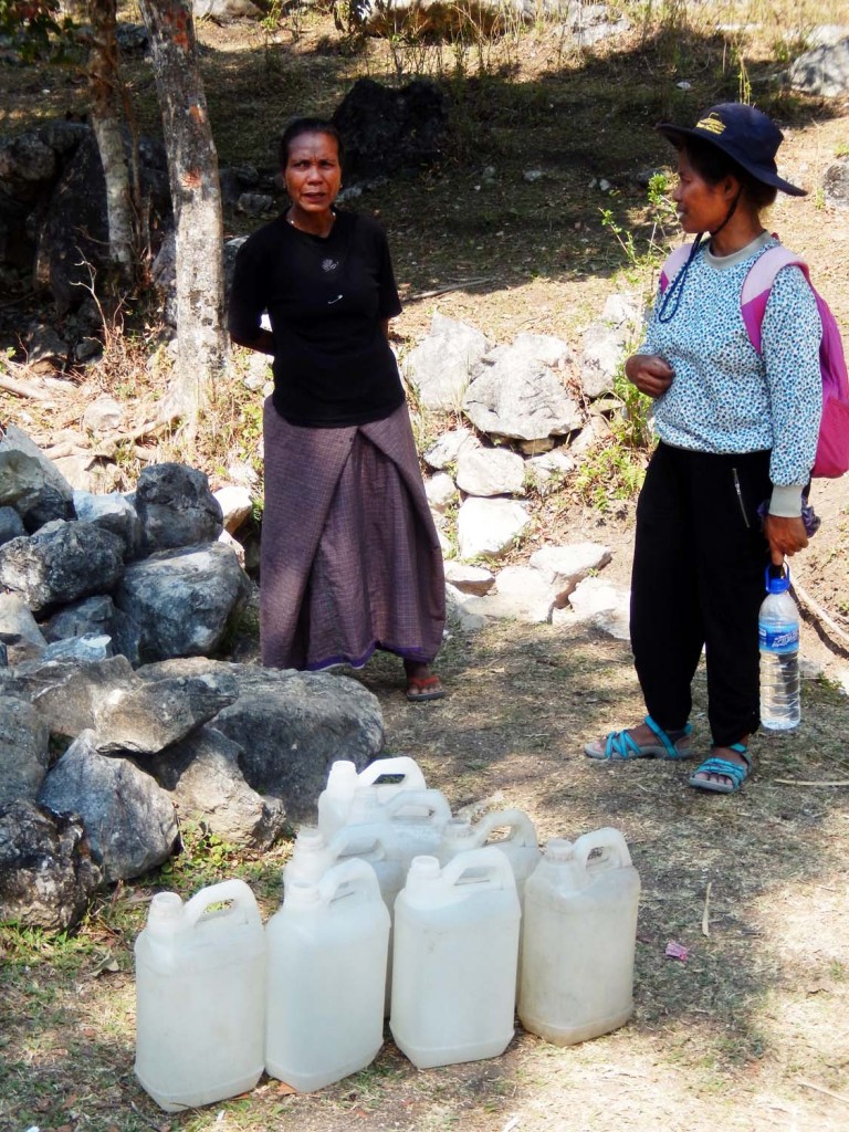 Leopoldina Guterres (right) talks with a local villager at a fresh-water spring on a mountain in Baguia, where women gather every day to fill their jugs. Scientists say climate change could exacerbate dry-season water shortages in the mountains across Timor Leste.