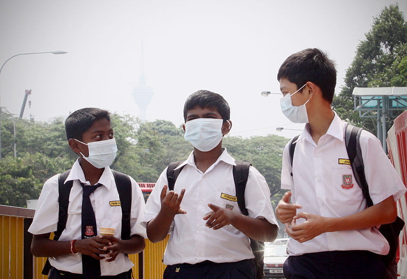 Malaysian schoolboys wear facemasks with Kuala Lumpur affected by haze pollution in 2012 (Photo by Firdaus Latif/Wikimedia Commons)