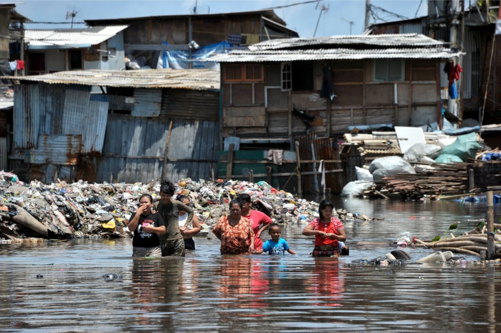 Women and children wade through their flooded Jakarta neighborhood in January, 2013. (AFP Photo)
