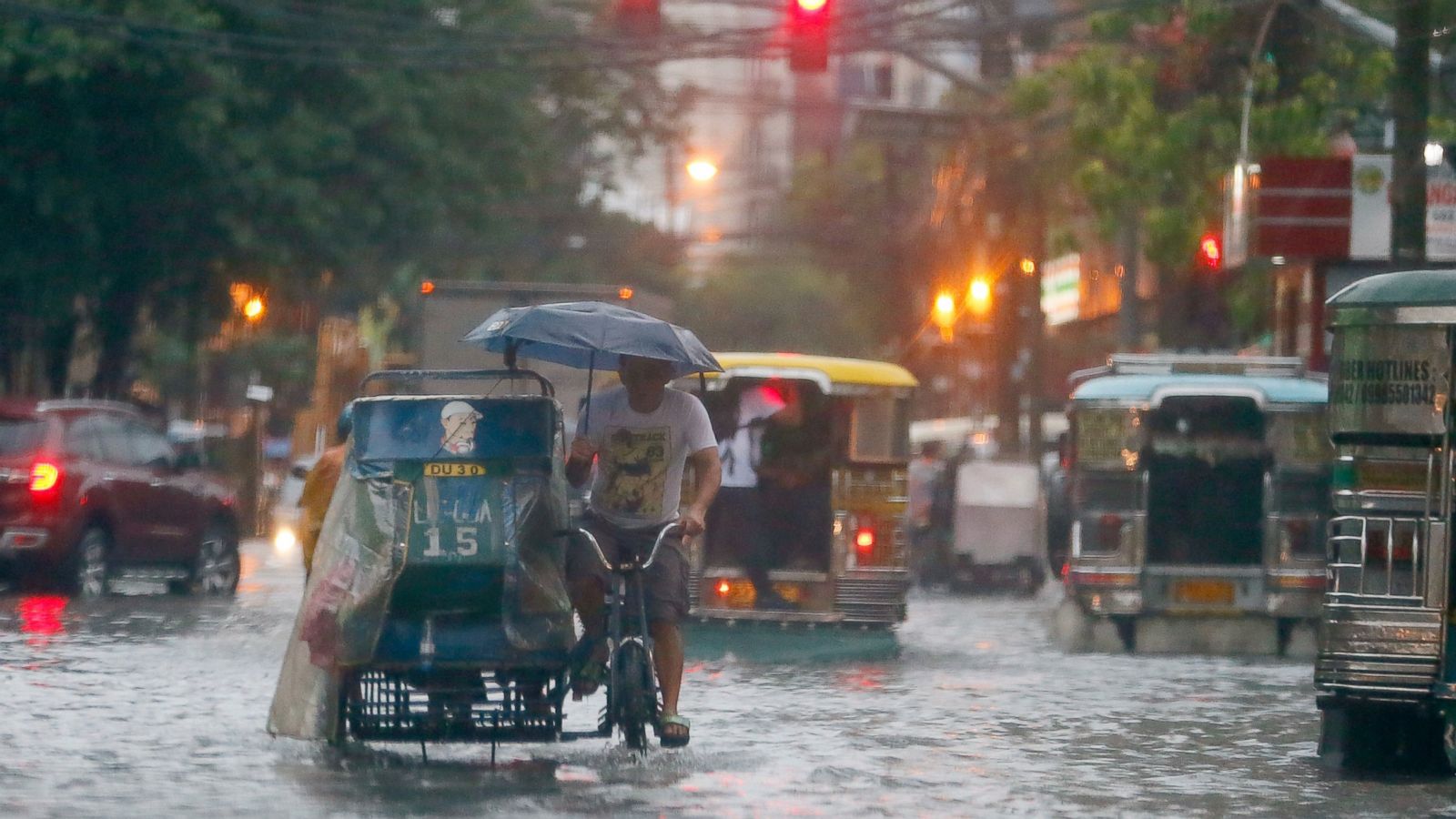 In this Aug. 26, 2016 file photo, commuters and motorists go on their way as heavy monsoon rains inundate low-lying areas in Manila, Philippines. Typhoons that slam into land in the northwestern Pacific _ especially the biggest tropical cyclones of the bunch _ have gotten considerably stronger since the 1970s, a new study concludes. (AP Photo/Bullit Marquez, File)