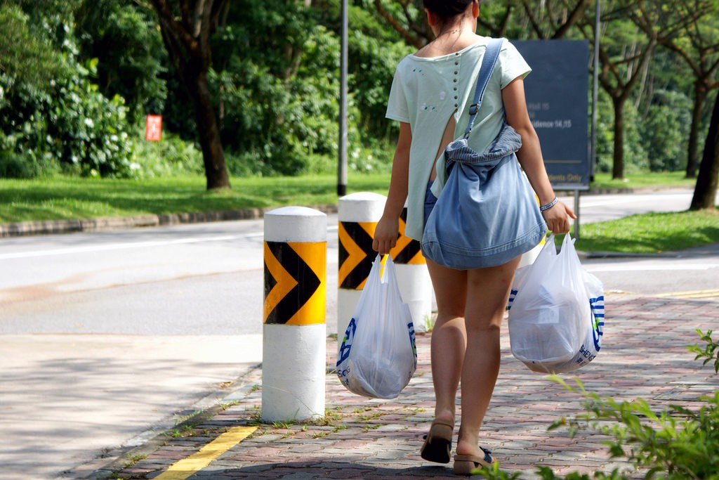 A woman carries her groceries home in plastic bags. Singapore threw away 822,000 tonnes of plastic last year, of which only seven per cent was recycled. Image: teddy-rised, CC BY-NC-ND 2.0