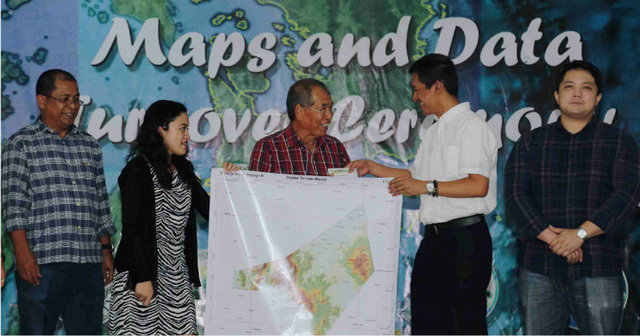 HAZARD MAPS. Visayas State University president Edgardo Tulin (in white) leads the turnover of flood and resource maps to officials of disaster-prone towns in Eastern Visayas. Photo by Aliana Gene Sarmiento/VSU Web Team