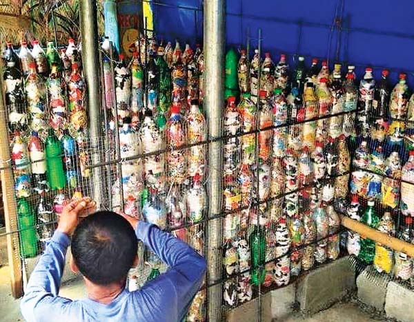 SOLID WALL — A worker cements the eco-brick-made wall of a new bathroom stall of The Circle Hostel-La Union in this September 29, 2017 photo. The Circle Hostel constructed eight additional bathroom stalls/showers made with over 1,000 eco-bricks. (Photos courtesy of The Circle Hostel)