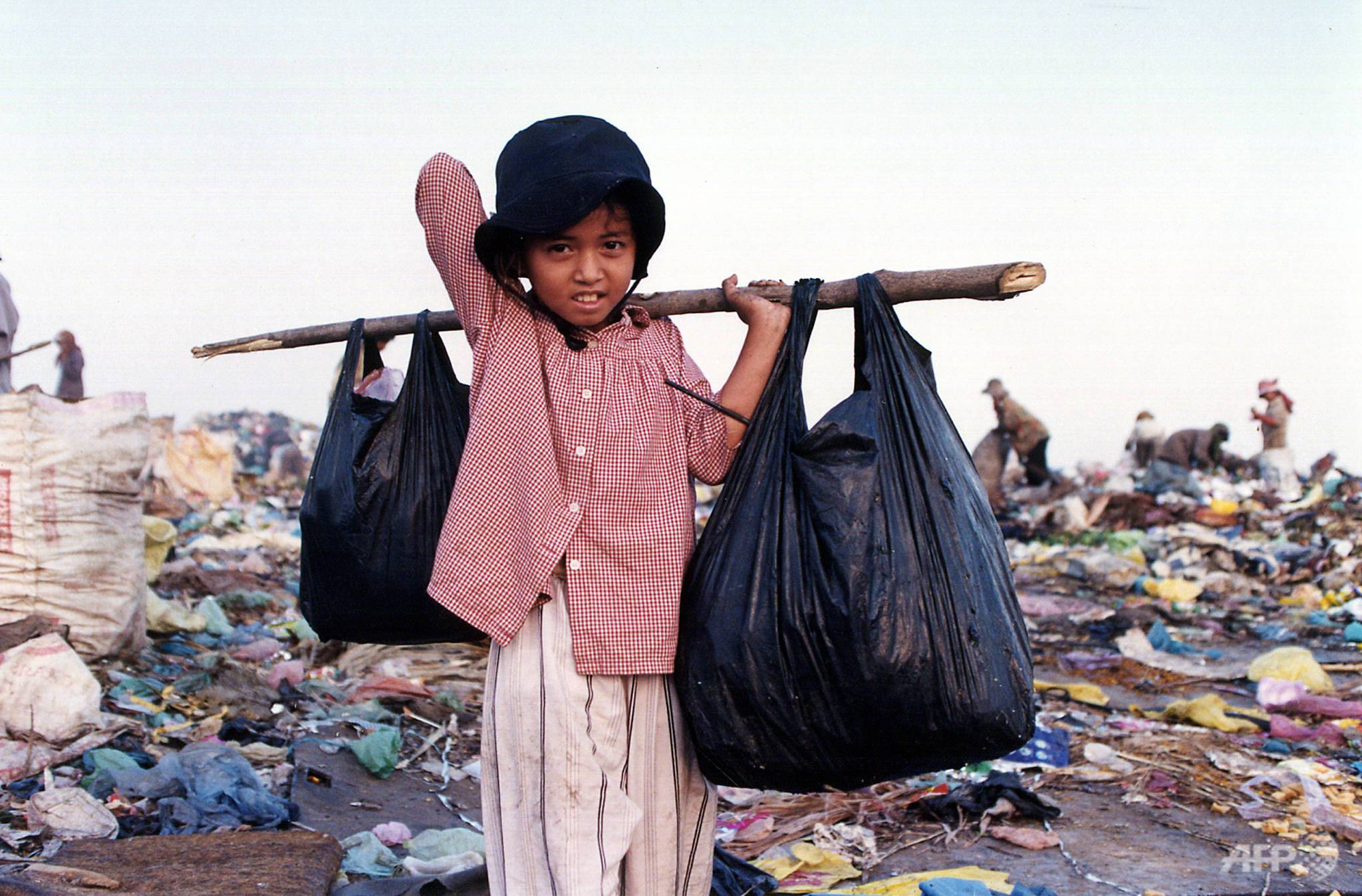 A young Cambodian scavenger heads home after collecting valuable articles for his livelihood from Phnom Penh’s garbage heap. (Photo: AFP/Khem Sovannara)