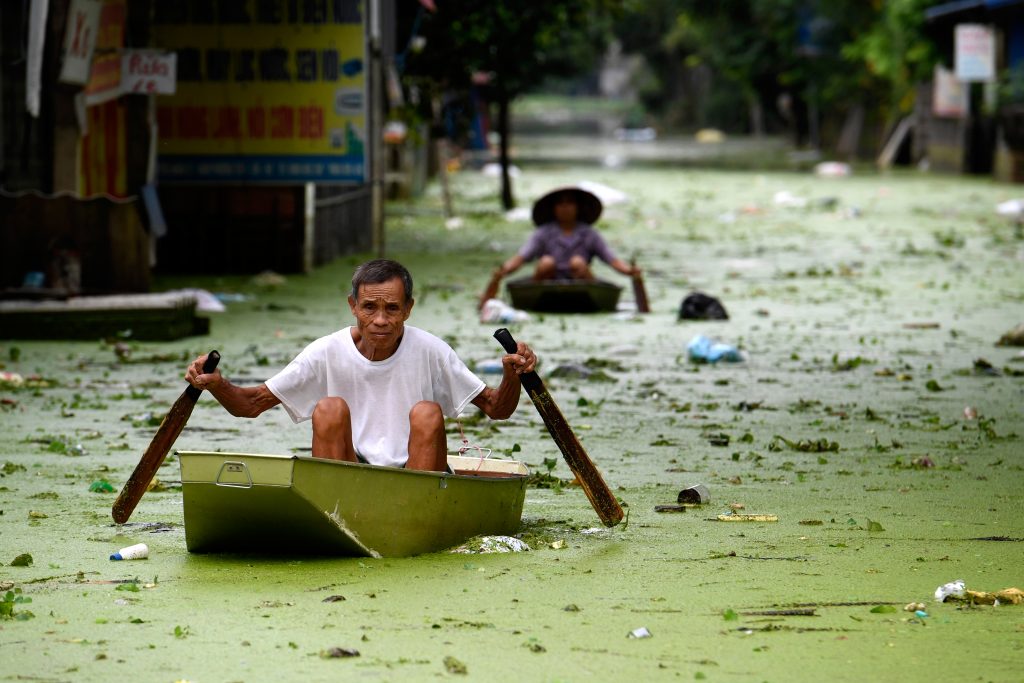 People row in boats through floodwaters in Hanoi’s suburban Chuong My district on August 2, 2018. Photo: Nhac Ngyuen/AFP