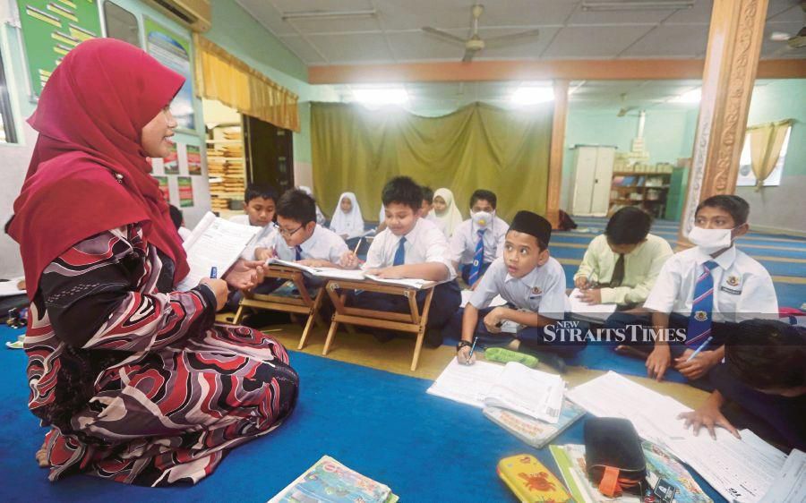 Two pupils wearing masks as they attend class at Surau Al-Hidayah in SK Kopok in Pasir Gudang yesterday. PIX BY HAIRUL ANUAR RAHIM