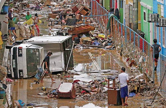 In Photo: A delivery van lies on its side after it was swept by heavy rains and strong winds brought about by a tropical storm that flooded Marikina City on August 12, 2018.