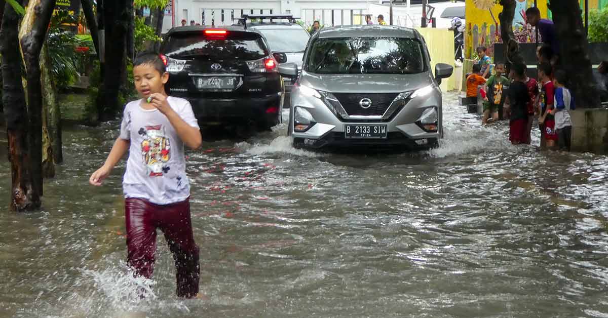 A boy plays on a flooded road after heavy rain in Jakarta. (AFP Photo)