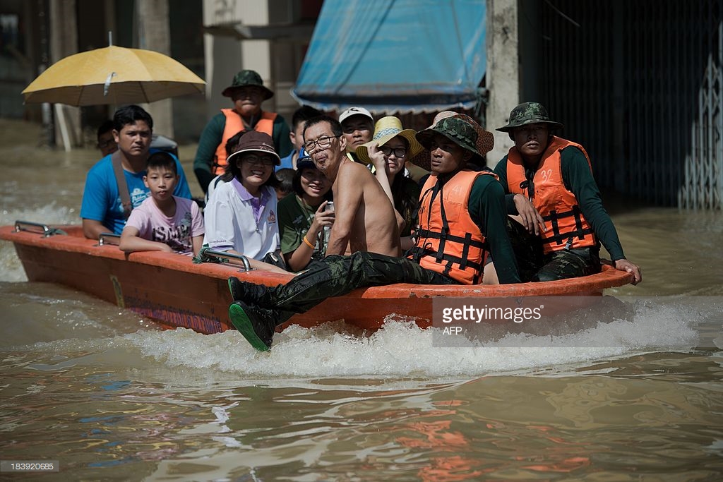Local residents use an army boat to cross floodwaters in Kabin Buri, east of Bangkok on October 10, 2013. The Disaster Prevention and Mitigation Department reported that 27 provinces in Thailand are still flooded and 31 people have died due to floods that have drenched swathes of Southeast Asia in recent weeks. AFP PHOTO/ Nicolas ASFOURI