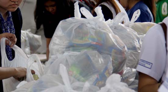Private citizens and military personnel join hands as they volunteer to re-pack relief goods composed of food clothing and other basic necessities at the Department of Social Welfare and development headquarters in Pasay, Philippines November 18, 2013