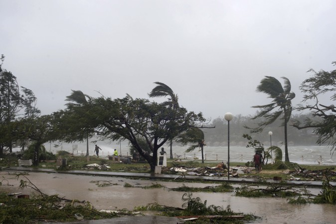 People walk along the shore where debris is scattered in Port Vila, Vanuatu, March 14, 2015. (AP Photo/UNICEF Pacific, Humans of Vanuatu)