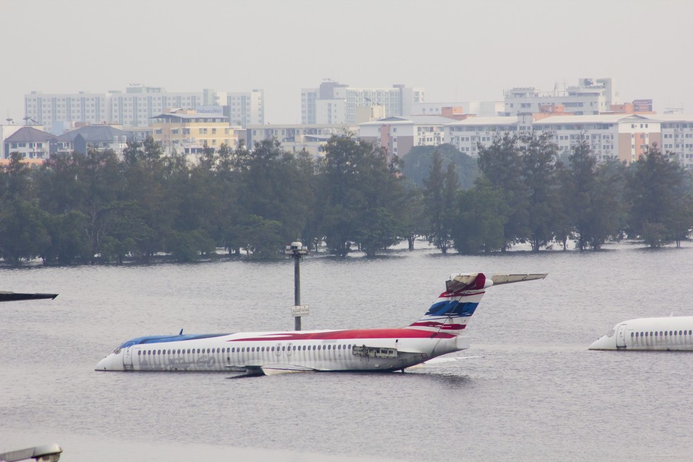 An airplane is partially submerged by floodwaters in Bangkok, Thailand, in 2011. Climate change impacts can cause hundreds of millions of dollars of losses to businesses. Image: Onizu3d/Shutterstock.com